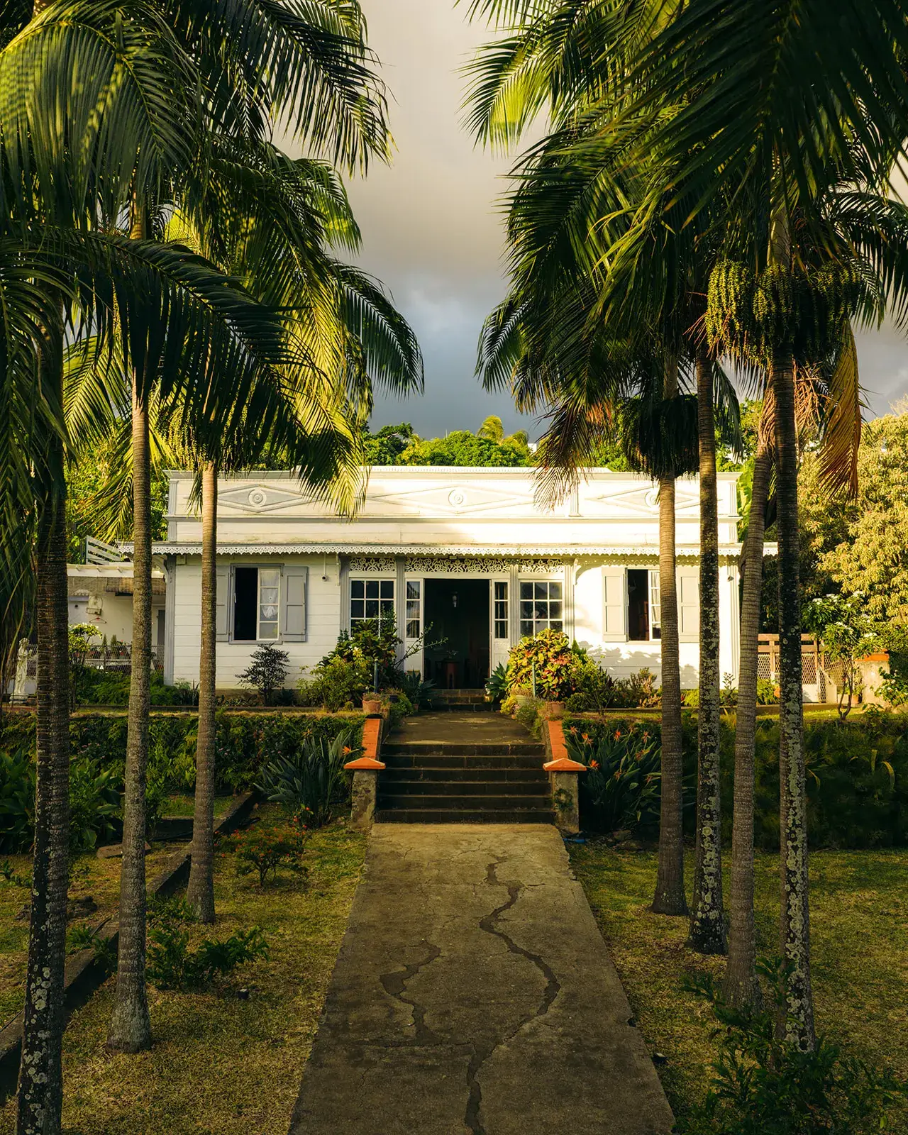 Maison créole historique de 1933 aux Avirons à La Réunion entourée de palmiers tropicaux dans le domaine Les Ti Kaz d’Auguste